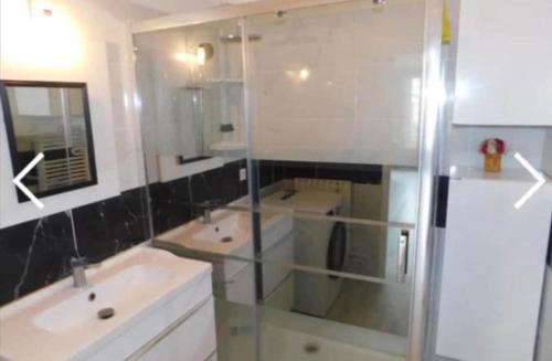 une salle de bain avec deux lavabos et une douche en verre dans l'établissement Spacious T3 in St-Raphaël, à Saint-Raphaël