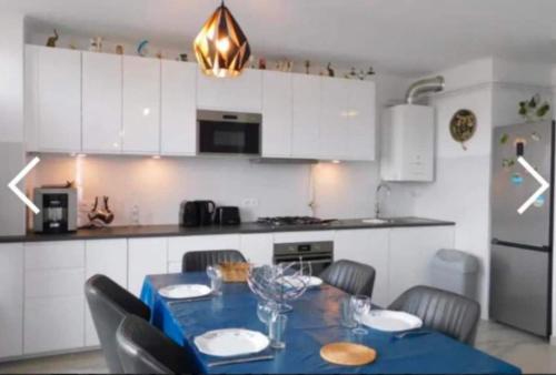une cuisine avec une table et des chaises et une cuisine avec des armoires blanches dans l'établissement Spacious T3 in St-Raphaël, à Saint-Raphaël