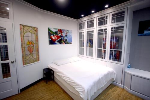 a white bedroom with a bed and windows at 豐原廟東自助民宿 in Fengyuan