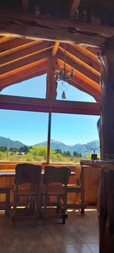a room with a table and chairs and a view of a mountain at Los Trevelinos in Trevelin