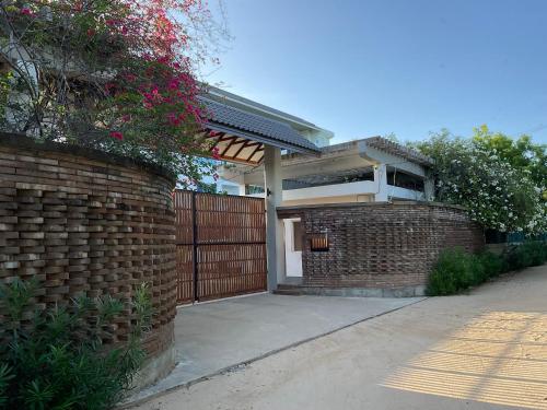 a house with a brick wall and a fence at Beach Bliss in Trincomalee