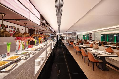 a restaurant with long tables with plates of food at Grand Mercure Shenzhen Guangming in Shenzhen