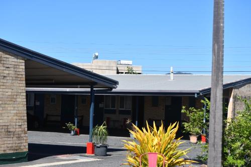 a building with a garage with a roof at Royal Motel Rockhampton in Rockhampton
