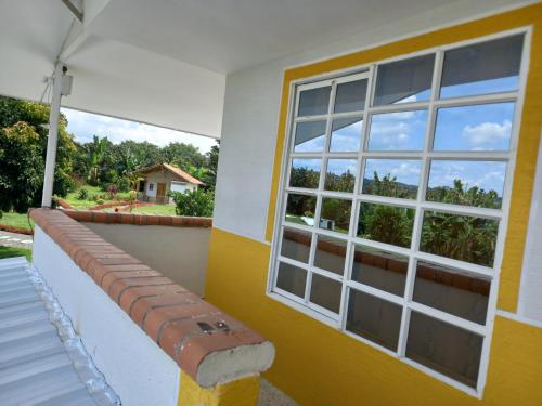 a yellow and white house with a window at Alojamiento Sol de Maíz in Quimbaya
