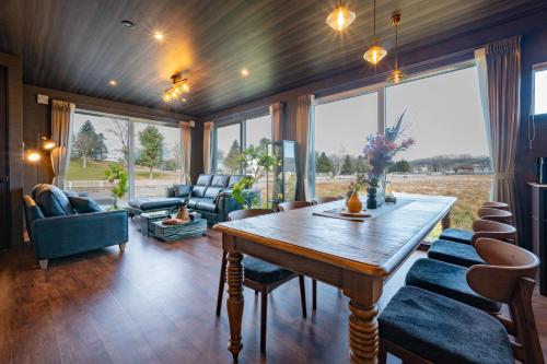 a living room with a wooden table and chairs at The Horizon Residence in Makubetsu