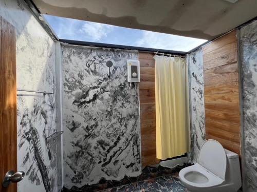 a bathroom with a shower and a toilet in it at นาน้าหมูฟาร์มสเตย์ NanamooFarmStay in Trang