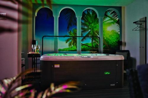 a room with a tub with a painting of a palm tree at Wellness-Oase in Kerkrade
