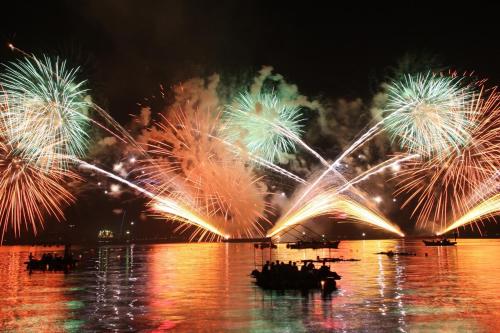 a group of people in a boat in the water with fireworks at UMIIE-日置浜- Private STAY in Miyazu
