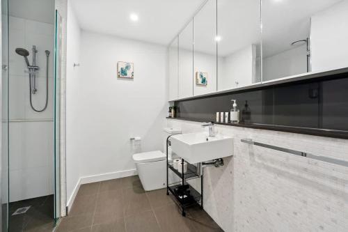 a bathroom with a toilet and a sink and a shower at Riverina - Ultimate Footscray Getaway with parking in Melbourne