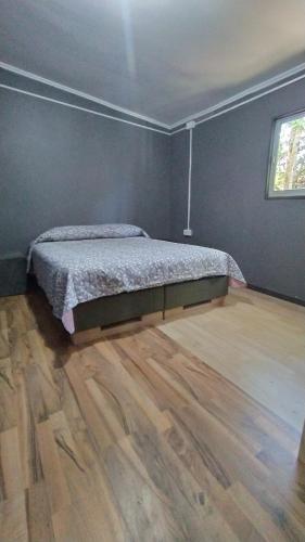 a bedroom with a bed and a wooden floor at Cabañas del Escultor Cabaña Canelo in Valdivia