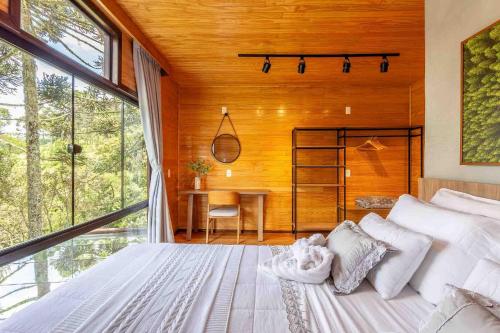 una camera da letto con un letto grande e una scrivania di Chalé O Canto da Araponga a Águas Brancas