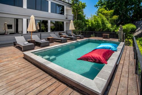 a swimming pool with a deck and a house at Bella Residence Pererenan in Canggu
