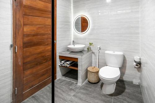 a bathroom with a white toilet and a sink at Bella Residence Pererenan in Canggu