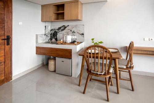 a kitchen with a table and two chairs and a counter at Bella Residence Pererenan in Canggu
