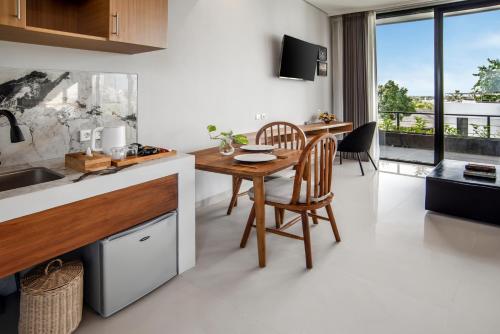 a kitchen with a wooden table and a dining room at Bella Residence Pererenan in Canggu