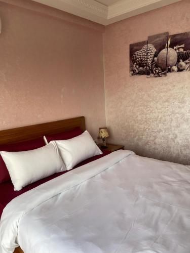 a bedroom with a large bed with white sheets at luxury apartment in Agadir
