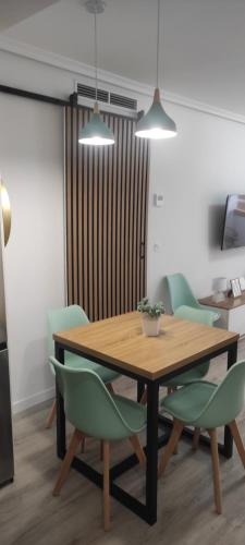 ein Esszimmer mit einem Holztisch und grünen Stühlen in der Unterkunft Marina Golden Choice - Piso nuevo a 350m playa in Oropesa del Mar
