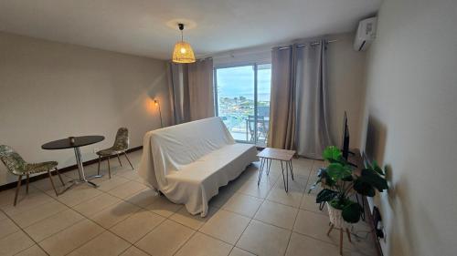 a living room with a white couch and a window at Conveniently located, ideal! in Mont-Dore
