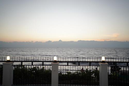 a view of the ocean at sunset from a fence at Golden Sands Cherai in Cherai Beach