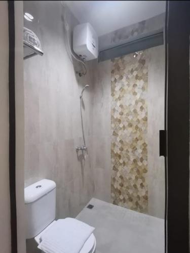 a bathroom with a white toilet and a shower at Phoenix Living in Surabaya