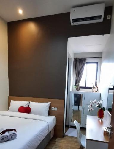 a bedroom with two beds and a desk and a chair at Phoenix Living in Surabaya