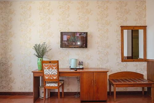 a wooden desk with a chair and a mirror at Tre Xanh Hotel in Pleiku