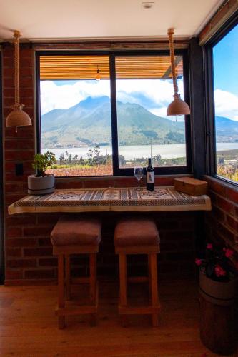a bar with a window with a view of the mountains at Yaktari Cabaña del Sol in Otavalo