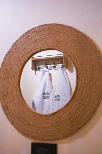 a mirror with three white towels hanging on a rack at Yaktari Cabaña del Sol in Otavalo