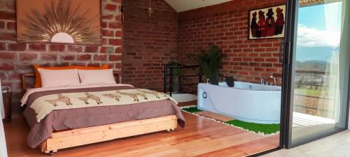 a bedroom with a bed and a bath tub at Yaktari Cabaña del Sol in Otavalo