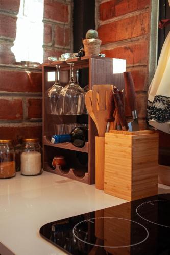 a kitchen counter with a knife block and wine bottles at Yaktari Cabaña del Sol in Otavalo