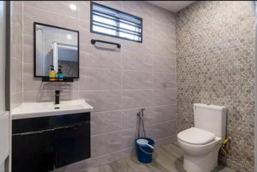 a bathroom with a toilet and a sink and a mirror at Luxury Villa in Ayer Keroh