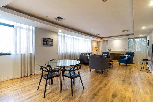 a living room with a table and chairs at LFlats Hotel Alameda Lorena Jardins in Sao Paulo