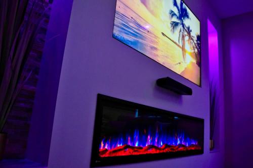 a living room with a fireplace and a tv at Wellness-Oase in Kerkrade