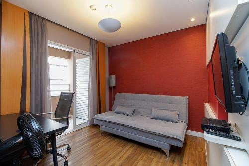 a living room with a couch and a tv at LFlats no Hotel Stella Vega (EX-Mercury Ibirapuera) in Sao Paulo