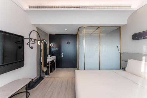 a hotel room with a bed and a sink at Atour X Hotel Renmin Bridge South Metro Panmen Scenic Area Suzhou in Suzhou