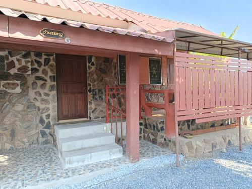a building with a porch and stairs on it at บ้านไร่ภูวังน้ำ in Ban Khlong Ki