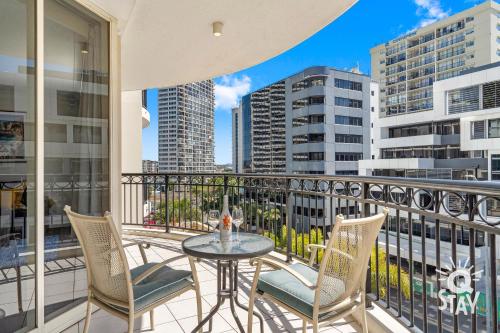 a balcony with a table and chairs and buildings at Chevron Renaissance - QStay in Gold Coast