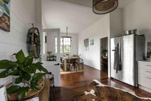 a kitchen with a refrigerator and a dining room at Black Cockatoo Bangalow in Binna Burra