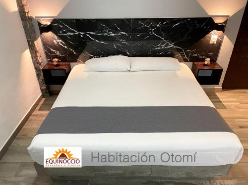 a bedroom with a bed with a black head board at Posada Equinoccio in Bernal