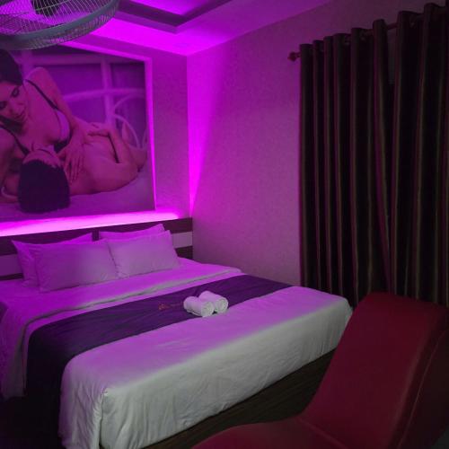 a bedroom with a bed with a pink lighting at Phương Anh Hotel Dĩ An in Dĩ An