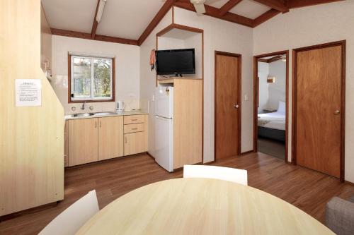 a kitchen with a table and a room with a bed at BIG4 South Durras Holiday Park in Durras