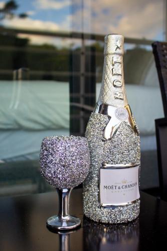 a bottle of champagne and a wine glass on a table at Premium Studio with Pool View in Mandeville