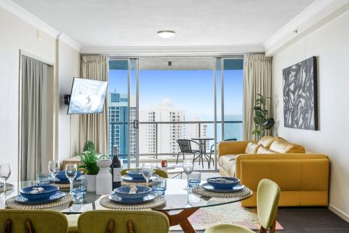 a living room with a table and a couch at Chevron Renaissance - QStay in Gold Coast
