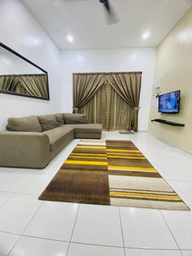 a living room with a couch and a television at Homestay Hj Esmon Parit Raja 4 UTHM in Parit Raja