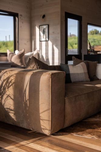 a brown couch sitting in a living room at Black Cockatoo Coorabell in Coorabell Creek