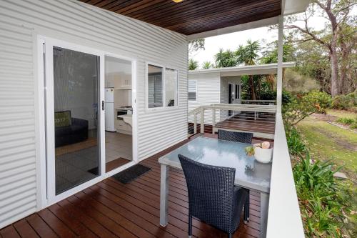 a patio with a table and chairs on a deck at BIG4 South Durras Holiday Park in Durras