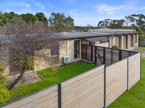 una casa con una valla delante de un patio en The Sandyplace, en Inverloch