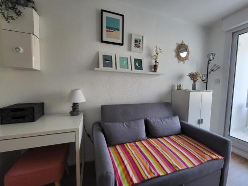 un salon avec une chaise, une table et un bureau dans l'établissement Appartement pour 2, balcon, parking, près plage – Saint Brevin l'Océan - FR-1-364-176, à Saint-Brévin-les-Pins