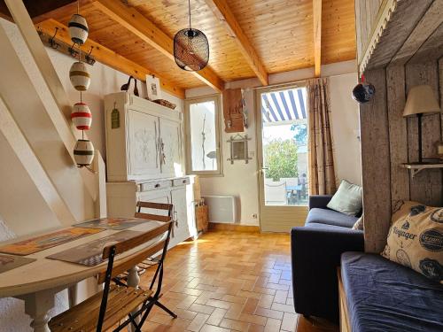 un salon avec une table et un canapé dans l'établissement Maisonnette proche plage et forêt, parking, wifi - FR-1-476-230, à La Faute-sur-Mer
