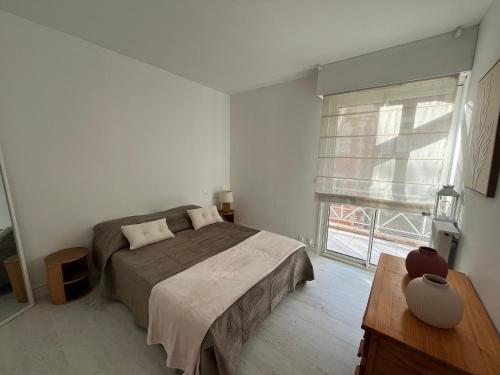 une chambre avec un lit et une grande fenêtre dans l'établissement Appartement T3 en bord de mer avec parking sécurisé et WiFi - FR-1-374-230, à Arcachon